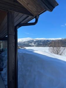 Aussicht von der Veranda eines Hauses im Schnee in der Unterkunft Dyrhaug - hytte med utsikt over Krøderen in Noresund