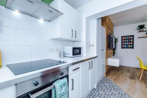 切斯特的住宿－NEW! Stylish 2-bed home, in Chester by 53 Degrees Property, Ideal for Long Stays, Great location - Sleeps 6，厨房配有白色橱柜和炉灶烤箱。