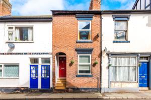 a brick house with blue doors on a street at NEW! Stylish 2-bed home, in Chester by 53 Degrees Property, Ideal for Long Stays, Great location - Sleeps 6 in Chester