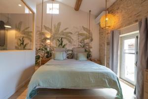 1 dormitorio con 1 cama grande y una pintura en la pared en Songes de vigne, en Bagnols