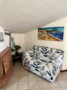 a living room with a couch and a painting on the wall at Il Bacio del Mare in Agropoli