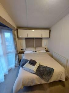 a bedroom with a large bed and a window at Drumrammer Farm Lodge in Ahoghill