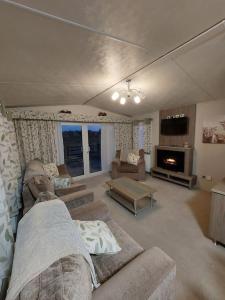 a living room with two couches and a fireplace at Drumrammer Farm Lodge in Ahoghill