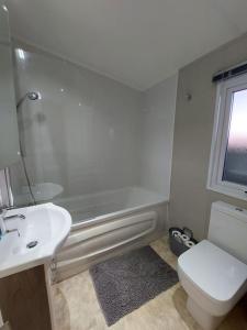 uma casa de banho com um lavatório, um WC e uma banheira em Drumrammer Farm Lodge em Ahoghill