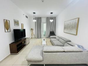 ein Wohnzimmer mit einem Sofa und einem TV in der Unterkunft A cozy place like home in Dubai