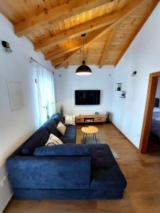 a living room with a blue couch and a tv at Holiday home Lunnis - Total peace and serenity in Velika Čista