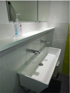 a white sink in a bathroom with a mirror at Auberge de jeunesse HI Millau La Maladrerie in Millau