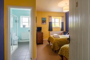 a bedroom with two beds and a bathroom at East Trewent Farm in Pembroke