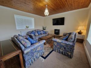 ein Wohnzimmer mit Sofas und einem Flachbild-TV in der Unterkunft Lewis Gethin House, Newly renovated cottage sleeps 9, close to bike park wales in Merthyr Tydfil