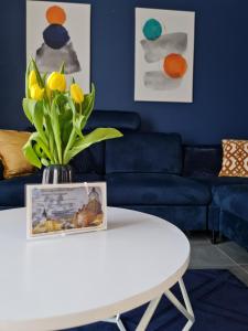 a living room with a blue couch and a white table at Apartamenty Nowickiego in Lublin