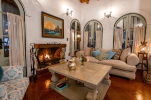 a living room with a table and a fireplace at Casona La Chiquita in Chacras de Coria