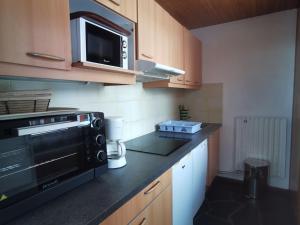 eine Küche mit einer Mikrowelle und einem schwarzen Gerät in der Unterkunft Appartement La Plagne, 3 pièces, 8 personnes - FR-1-181-2665 in La Plagne Tarentaise