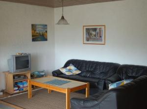a living room with a couch and a tv at Freyung, Ferienwohnung Sonnenschein in Schönberg
