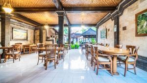 a restaurant with wooden tables and chairs at Cafe Wayan Cottages Senggigi in Senggigi 