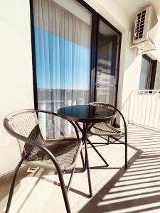 a patio table and two chairs on a balcony at The Palm 2 Apartment - family friendly, central, self check-in in Oradea