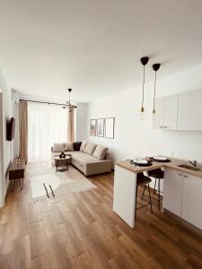 a white living room with a couch and a table at The Palm 2 Apartment - family friendly, central, self check-in in Oradea