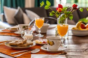 une table recouverte de assiettes de nourriture et de tasses de jus d'orange dans l'établissement Casona La Chiquita, à Chacras de Coria