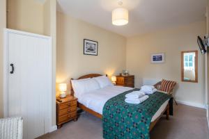 a bedroom with a bed and a chair with towels on it at East Trewent Farm in Pembroke