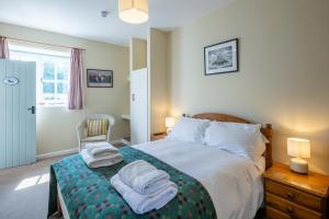 a bedroom with a bed with towels on it at East Trewent Farm in Pembroke