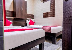 a room with two beds with red and white sheets at Chellam Residency in Chennai