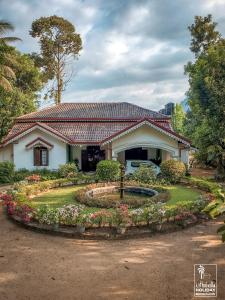 ein Haus mit einem Blumengarten davor in der Unterkunft Kithulvilla Holiday Bungalow in Kitulgala