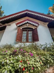 a house with a window and some flowers at Kithulvilla Holiday Bungalow in Kitulgala
