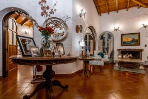 a room with a table with a vase of flowers on it at Casona La Chiquita in Chacras de Coria