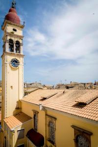 a clock tower on top of a building with a roof at Sunny Morning at Saint Spyridon by CorfuEscapes in Corfu Town