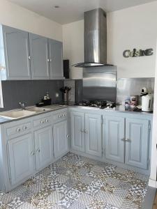 a kitchen with white cabinets and a stove top oven at Appartement vue sur la Rhune in Sare
