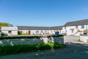 a house with a stone wall in front of a yard at East Trewent Farm in Pembroke