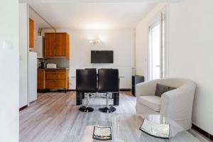 ein Wohnzimmer mit einem Sofa und 2 Stühlen sowie eine Küche in der Unterkunft Jolie petite maison Alicia - Jardin - Cité de l'Espace in Toulouse