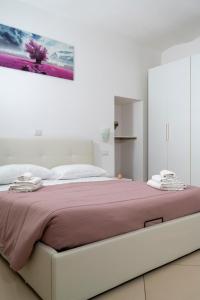 a bedroom with a large bed with a purple blanket at La casa di Thomas in centro in Matera