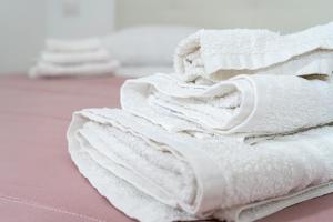 a pile of white towels sitting on a table at La casa di Thomas in centro in Matera +64 photos