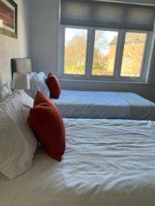 a bedroom with two beds with pillows and a window at Beck View House in Stockton-on-Tees