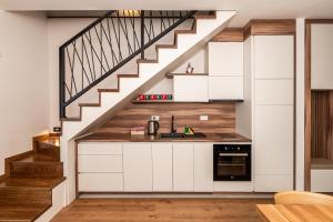 a kitchen with white cabinets and a staircase at Aparthotel RAJSKA in Jahorina