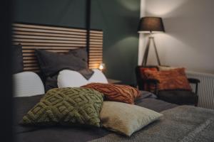 - une chambre avec 2 lits avec des oreillers et une lampe dans l'établissement EDLER WOHNRAUM Luxuriöses Studio im Zentrum mit Parkplatz, Einbaukaffeevollautomat, Netflix & Klimaanlage, à Zwickau