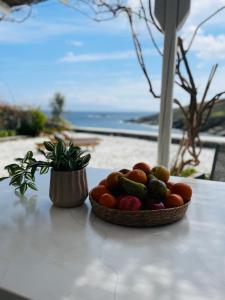 a bowl of fruit on a table next to a plant at Simousea in Kithnos