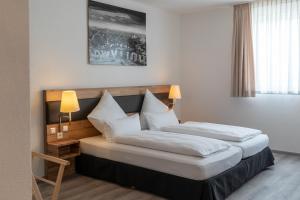 a hotel room with two beds with white pillows at Hotel in Laisen in Reutlingen