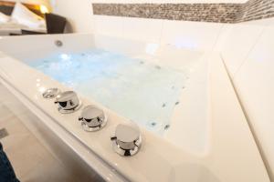 a bathroom with a tub with blue water at Hotel in Laisen in Reutlingen