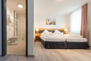 a bedroom with a large bed and a bathroom at Hotel in Laisen in Reutlingen +12 photos
