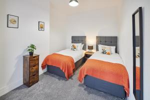 a bedroom with two beds and a mirror at Host & Stay - North Seaton Road in Newbiggin-by-the-Sea