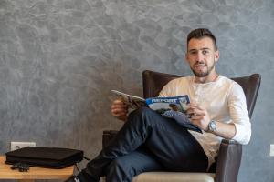 a man sitting in a chair reading a magazine at Hotel in Laisen in Reutlingen