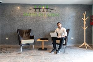 a man sitting in a chair with a laptop at Hotel in Laisen in Reutlingen