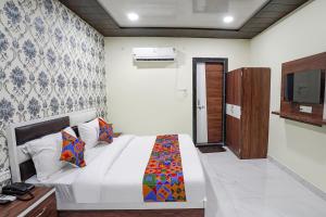 a bedroom with a bed and a television in it at FabHotel Rajdhani in Kānpur
