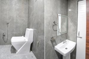 a bathroom with a white toilet and a sink at FabHotel Rajdhani in Kānpur