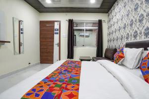 a bedroom with a bed with a colorful quilt on it at FabHotel Rajdhani in Kānpur