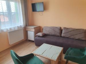 ein Wohnzimmer mit einem Sofa, Stühlen und einem Tisch in der Unterkunft Pension Zelený strom in Mikulov