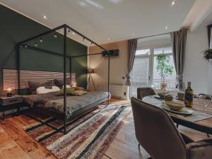 1 dormitorio con cama con dosel y mesa de comedor en EDLER WOHNRAUM Luxuriöses Studio im Zentrum mit Parkplatz, Einbaukaffeevollautomat, Netflix & Klimaanlage, en Zwickau