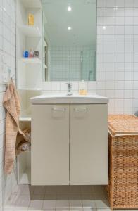 a white bathroom with a sink and a mirror at Super central - Unique studio apartment - 4 people in Oslo
