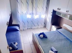 two beds in a room with blue sheets at Casa R&E in Valbrona